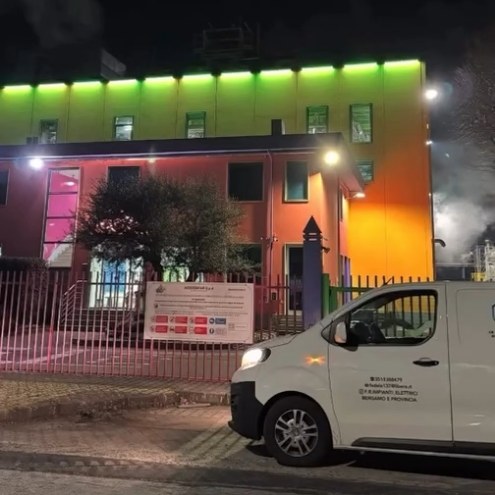 Furgone bianco F.R. Impianti Elettrici «Bergamo e provincia» di notte davanti a un edificio con luci verdi e rosa